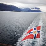フィヨルドを船尾のノルウェー国旗がはためいて